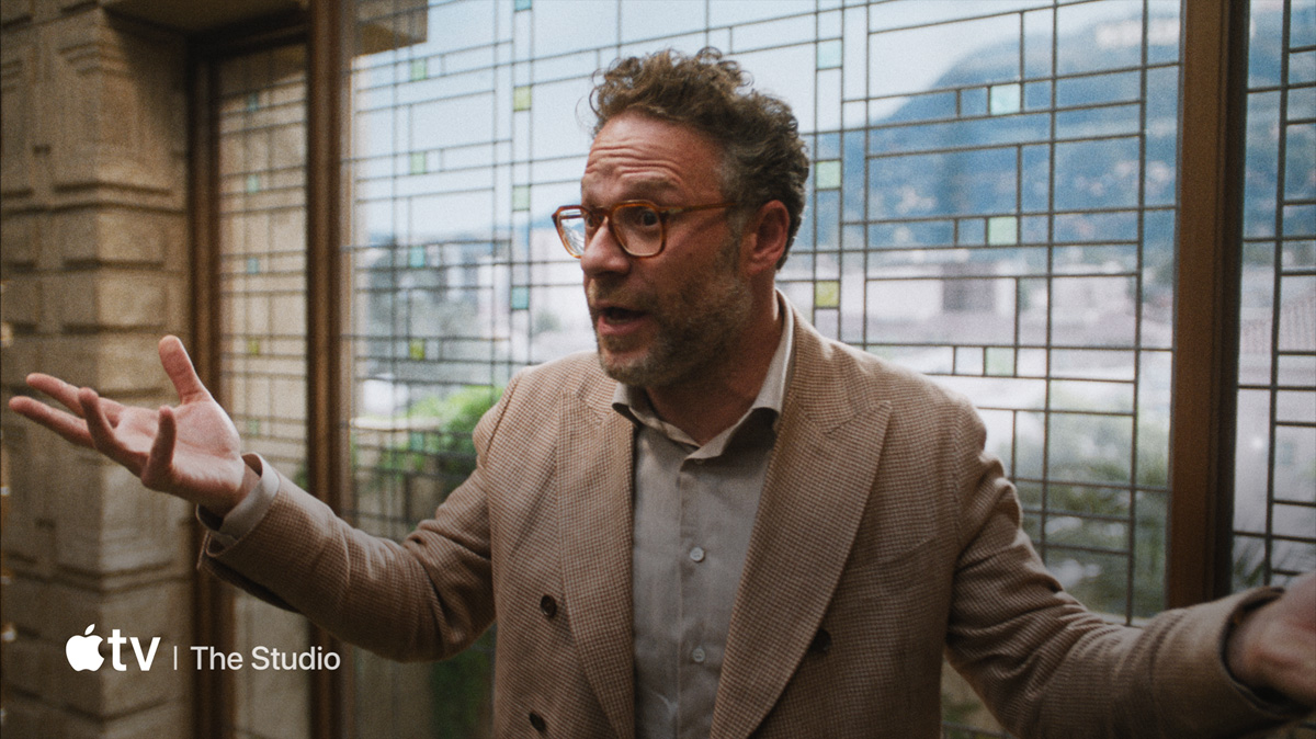 A flatscreen television showing videos of Apple TV shows and movies, Apple Music, and Apple Arcade.