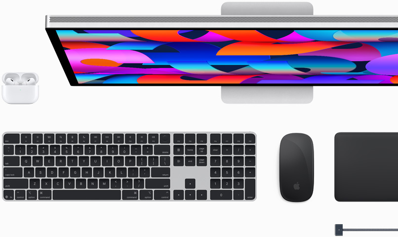 Acessórios para Mac: AirPods, Studio Display, Magic Keyboard, Magic Mouse, Magic Trackpad e cabo MagSafe para recarga na cor meia-noite.