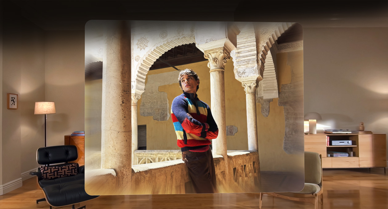 Spatial scene in photo of man leaning against balcony of winding courtyard, with depth and dimension in surroundings