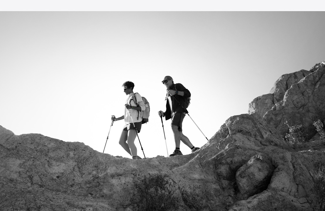 Two people wearing Apple Watch Ultra 3 hike a mountain trail